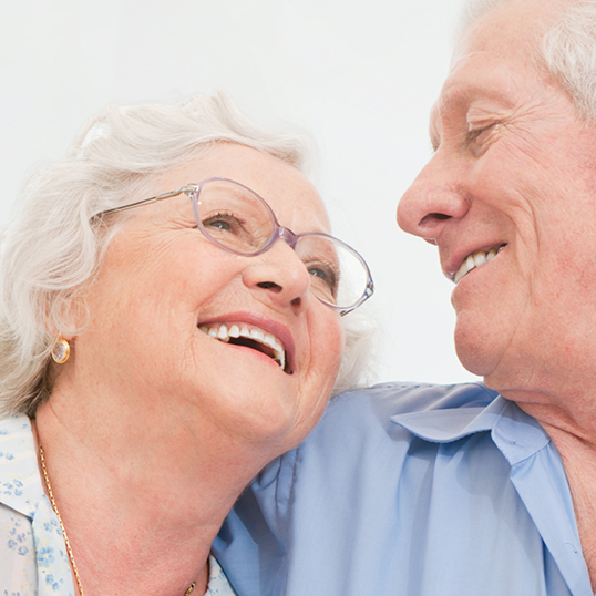 Zahnersatz - Glücklich lächelndes älteres Paar